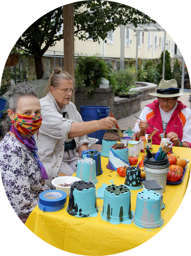 A group of people sitting around a table with cakes.